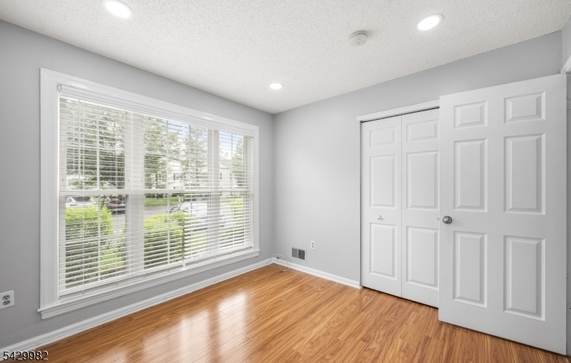 3702 Riddle Court, Unit 2 Bridgewater, NJ 08807 - Photo 17 of 20 a view of empty room with wooden floor and fan
