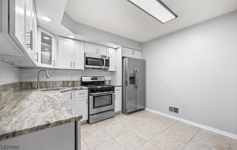 3702 Riddle Court, Unit 2 Bridgewater, NJ 08807 - Photo 8 of 20 a kitchen with stainless steel appliances granite countertop a stove a sink dishwasher a refrigerator and a microwave