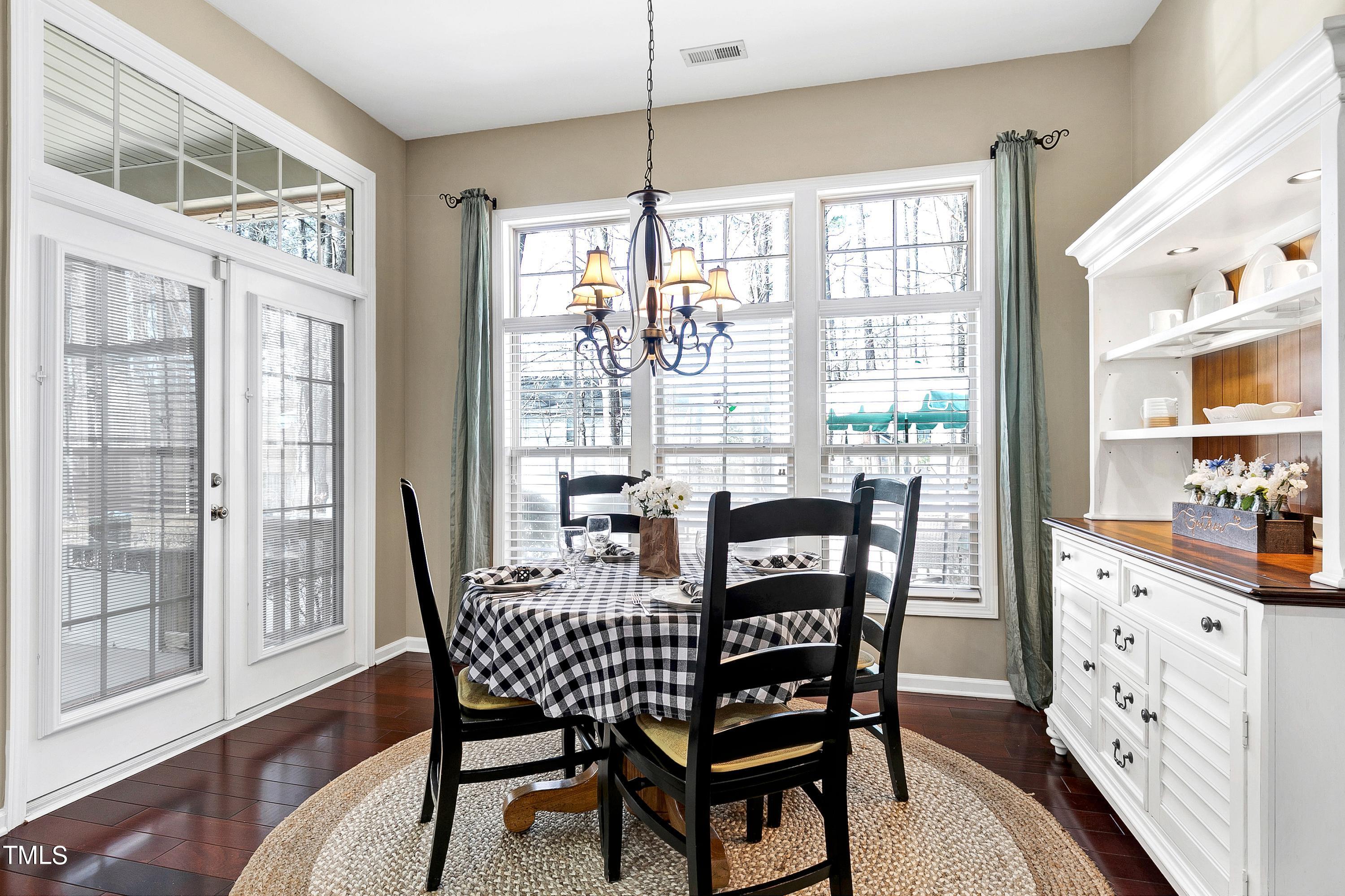6115 Leesburg Lane Raleigh, NC 27617 - Photo 17 of 46 a dining room with furniture a chandelier and wooden floor