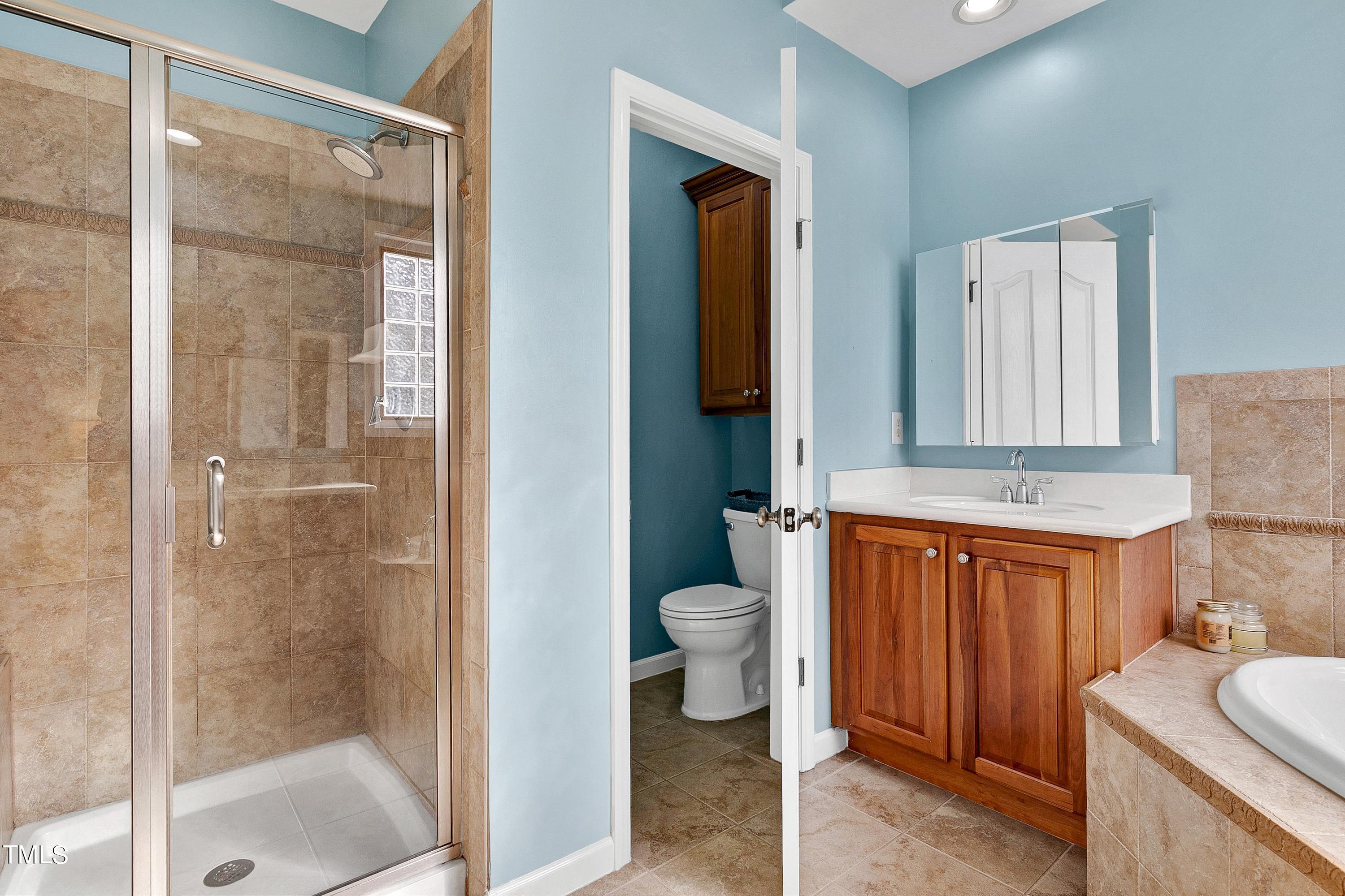 6115 Leesburg Lane Raleigh, NC 27617 - Photo 28 of 46 a bathroom with a granite countertop sink mirror vanity and toilet
