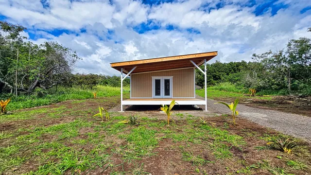 a backyard of a house with a garden and barbeque oven