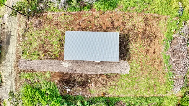 an aerial view of a house with a yard and potted plants