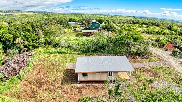 a view of a house with backyard and trees