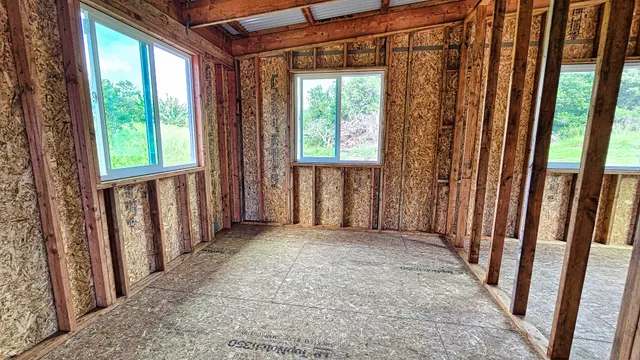 a view of an empty room with floor to ceiling window and ceiling fan
