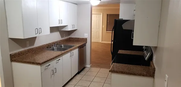 a kitchen with granite countertop a sink stove and cabinets