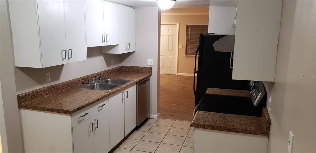 2052 Kings Highway, Unit 7 Clearwater, FL 33755 - Photo 2 of 16 a kitchen with granite countertop a sink stove and cabinets