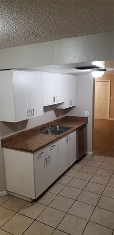 a kitchen with granite countertop a sink and cabinets
