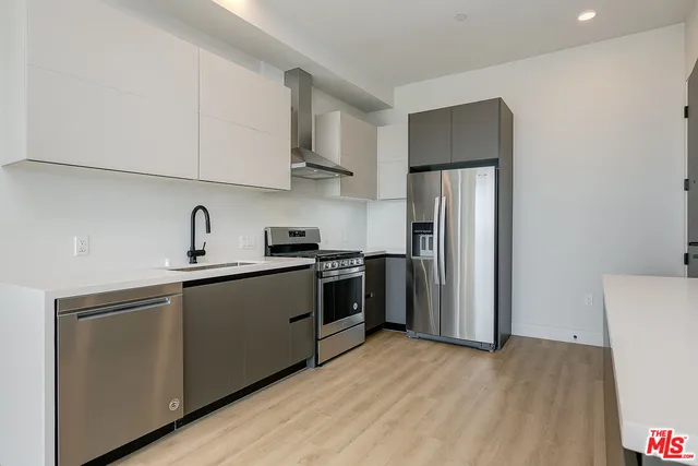 a kitchen with stainless steel appliances a refrigerator sink and cabinets