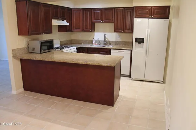 a kitchen with stainless steel appliances a refrigerator a stove a sink and a cabinets