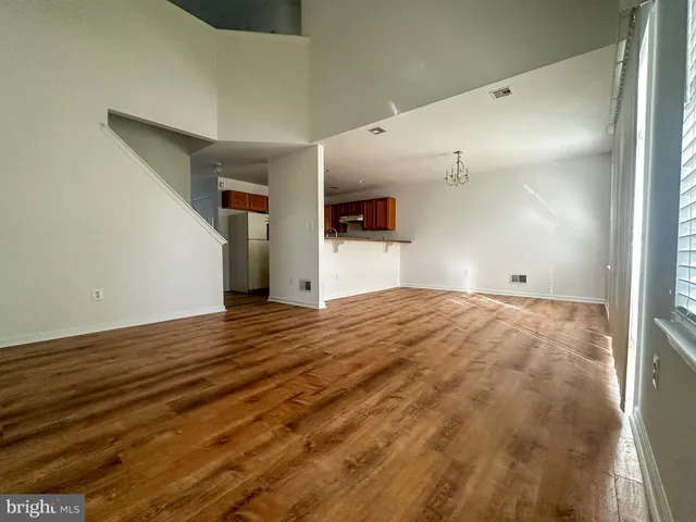 a view of empty room with wooden floor