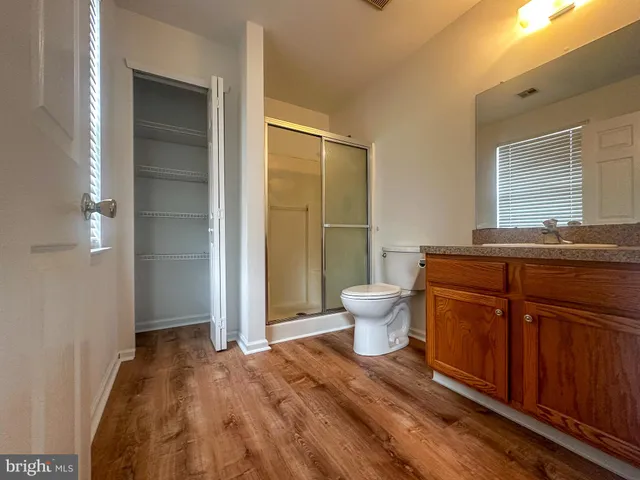 a spacious bathroom with a granite countertop toilet a sink and a mirror