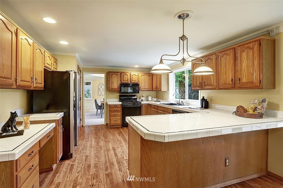 220 174th Street Southwest Bothell, WA 98012 - Photo 4 of 35 a kitchen with a sink a counter top space stainless steel appliances and cabinets