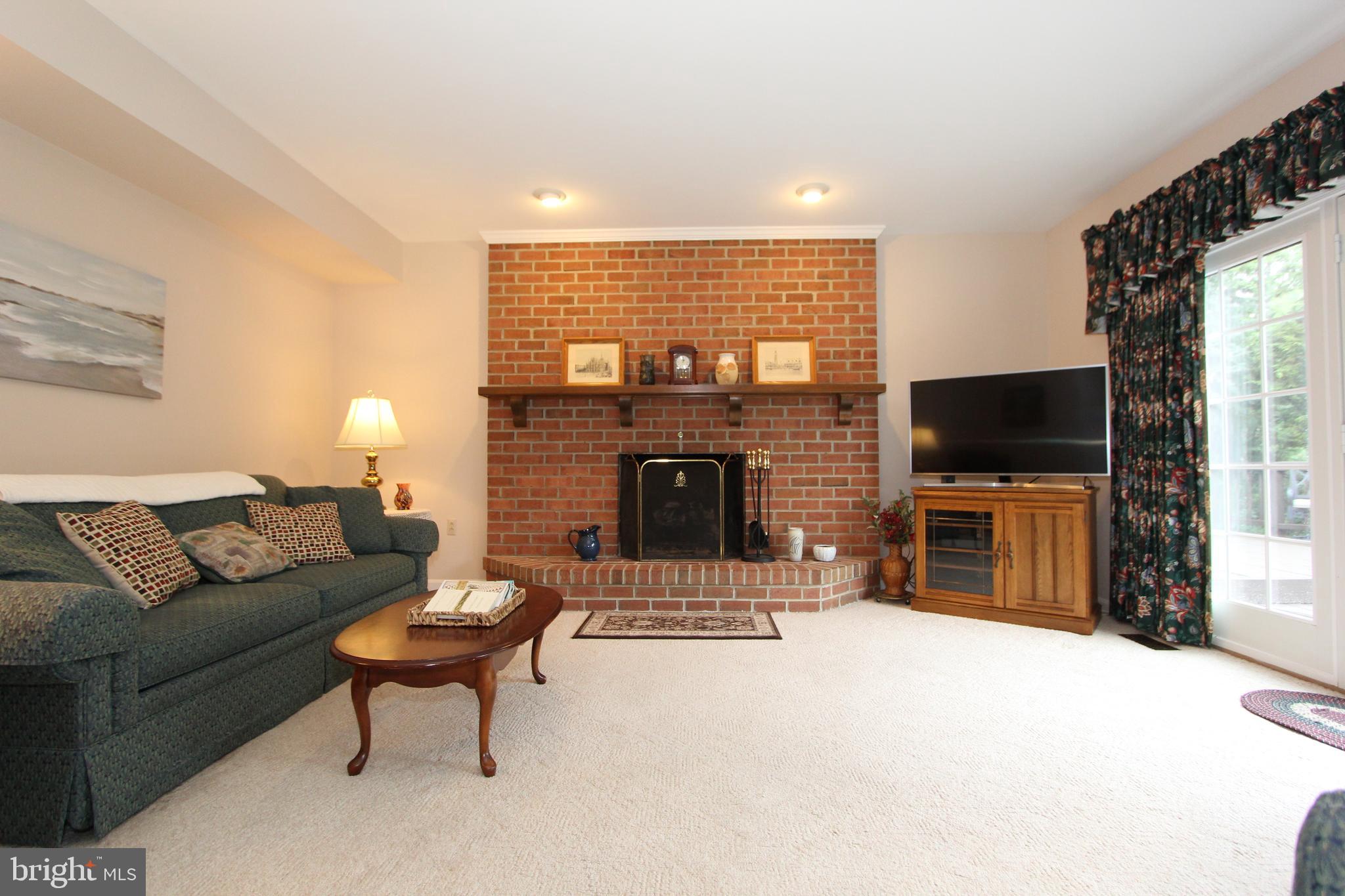 6670 Springhill Drive Frederick, MD 21702 - Photo 20 of 98 a living room with furniture a flat screen tv and a fireplace