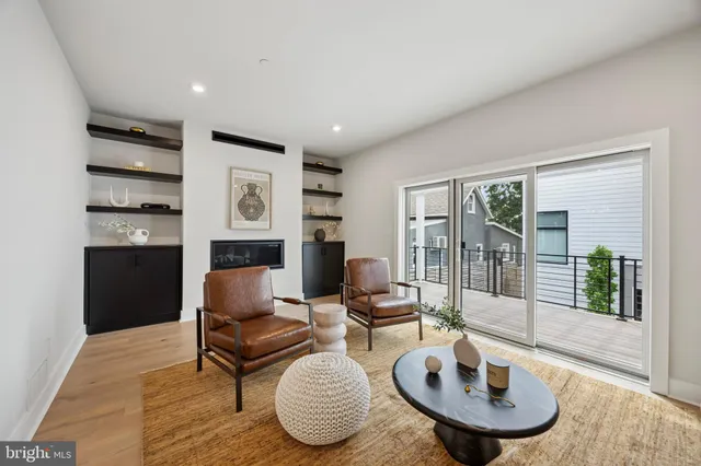 a living room with furniture a large window and kitchen view