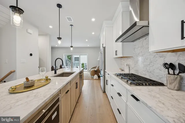 a kitchen with granite countertop a stove a sink a refrigerator and window