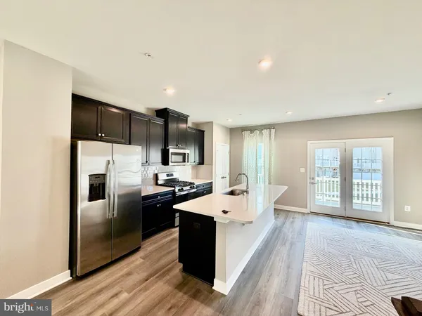 a view of open kitchen with a sink and cabinets