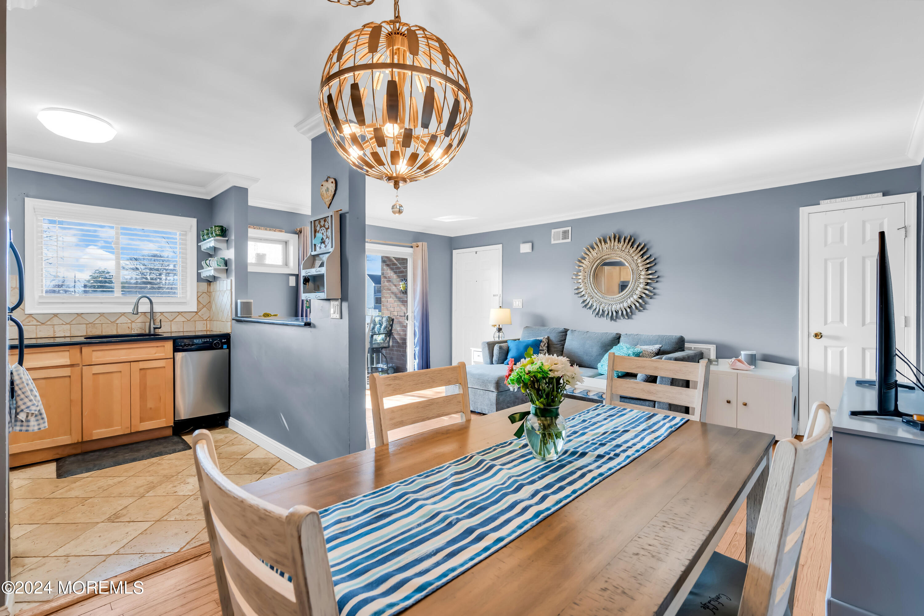 a view of a dining room with furniture a chandelier and wooden floor