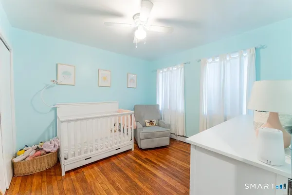 a living room with furniture and a baby crib