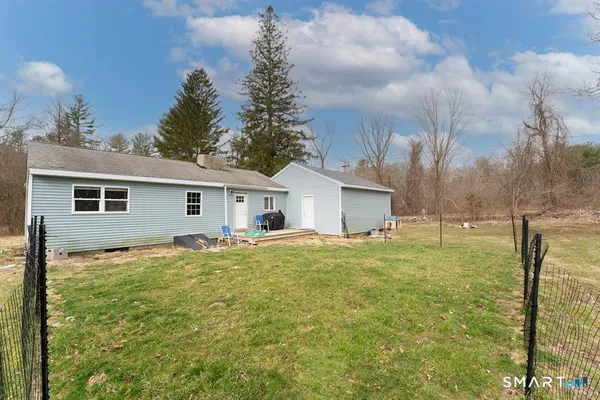 a view of a house with backyard and trees