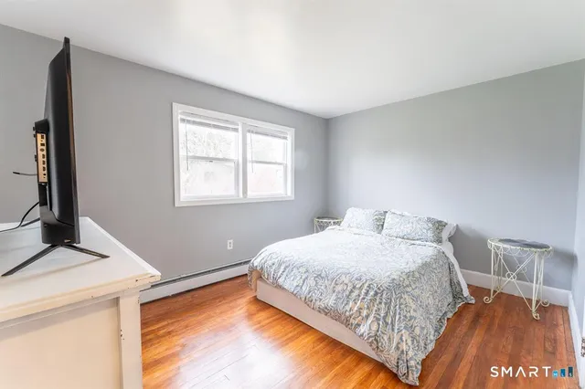 a bedroom with a bed and a flat tv screen on dresser