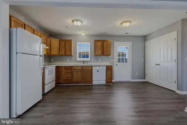 a kitchen with stainless steel appliances a sink cabinets and wooden floor