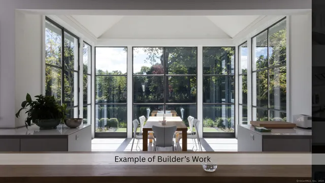 a dining room with wooden floor and floor to ceiling window