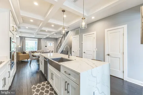 a kitchen with a sink appliances and wooden floor