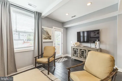 a living room with furniture flat screen tv and window