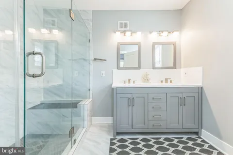 a bathroom with a double vanity sink mirror and shower