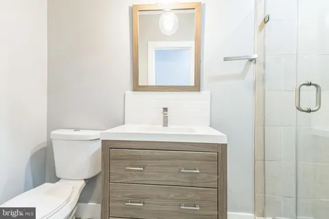 a bathroom with a sink a toilet and a mirror