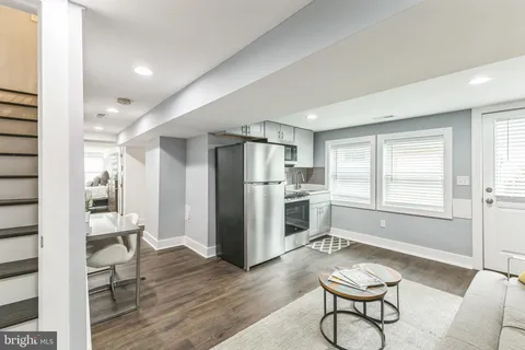 a kitchen with stainless steel appliances a refrigerator and wooden floor