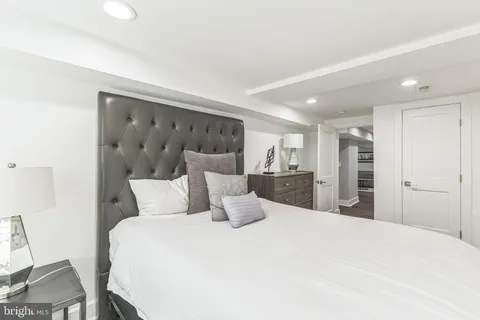 a large bed in a white room with a large mirror