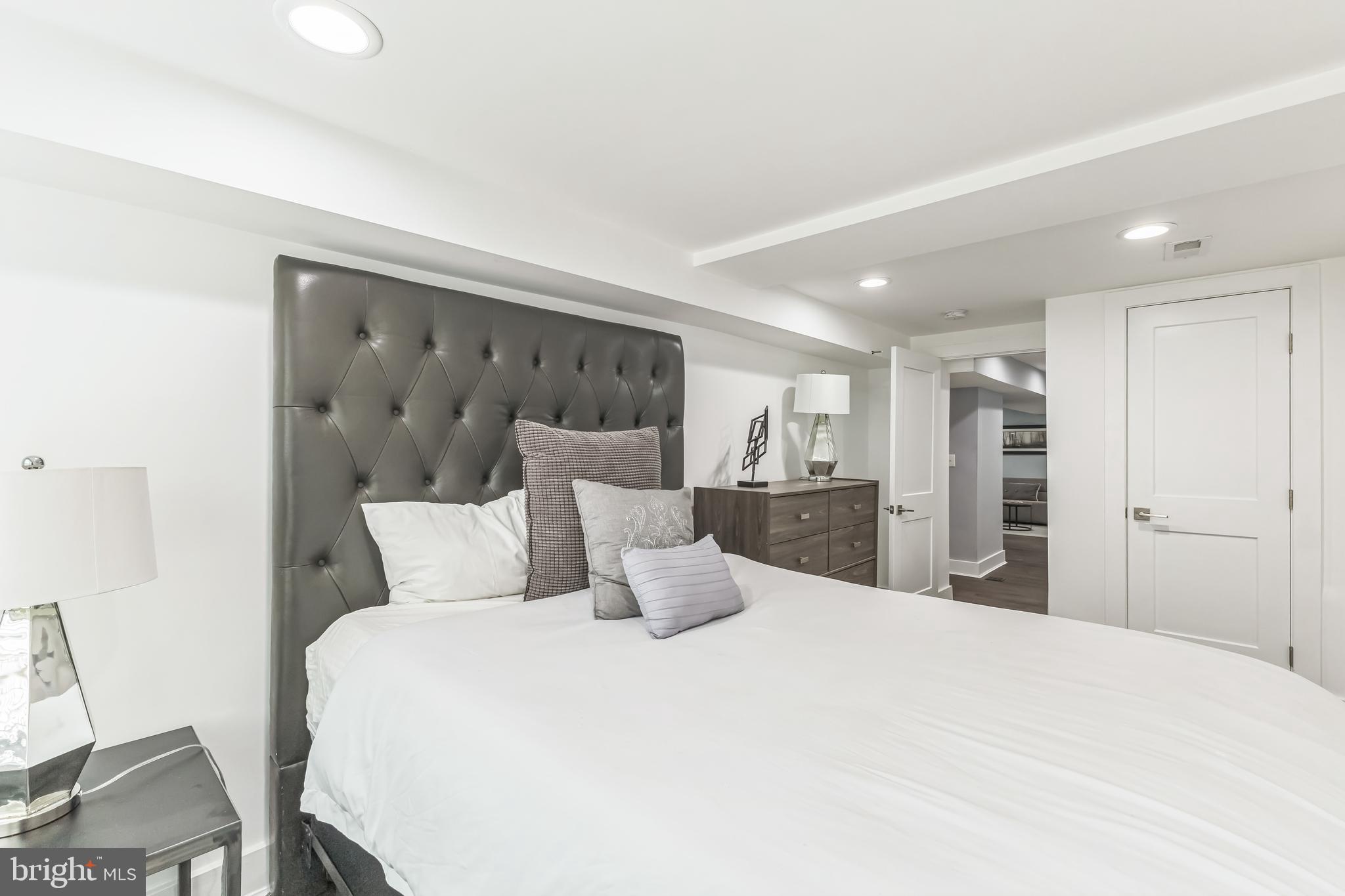 5623 Kansas Avenue Northwest Washington, DC 20011 - Photo 27 of 32 a large bed in a white room with a large mirror