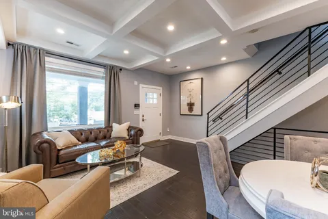 a living room with furniture wooden floor and a large window