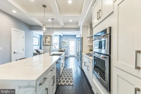 an open kitchen with a sink and stainless steel appliances