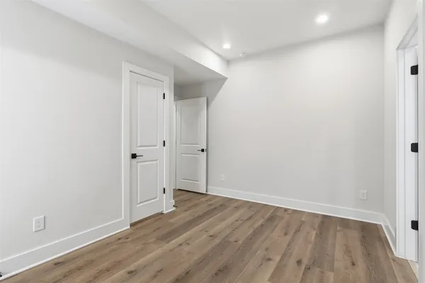 a view of an empty room with wooden floor