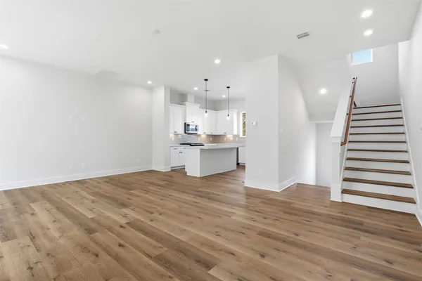 a view of a kitchen with wooden floor and electronic appliances