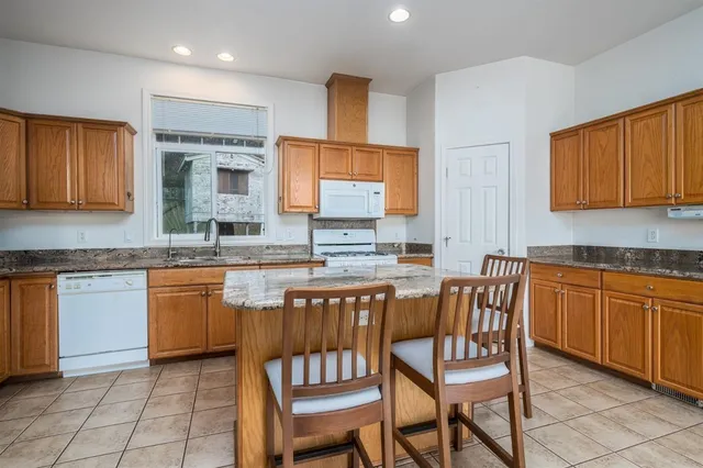 a kitchen with stainless steel appliances granite countertop wooden cabinets a sink and dishwasher