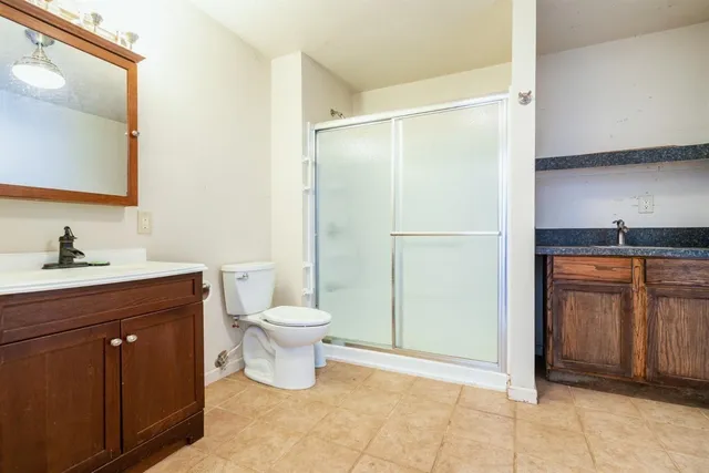 a bathroom with a sink a toilet and shower