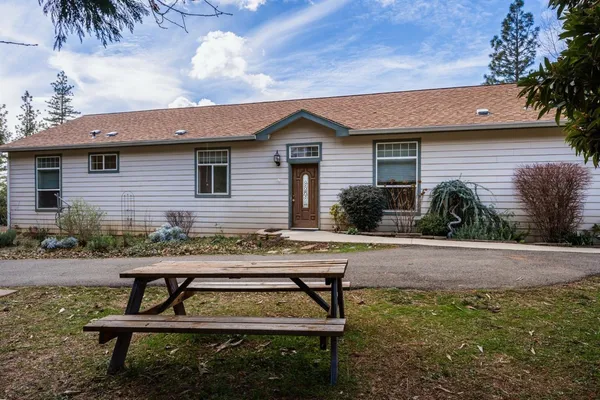 a view of a house with a yard and sitting area