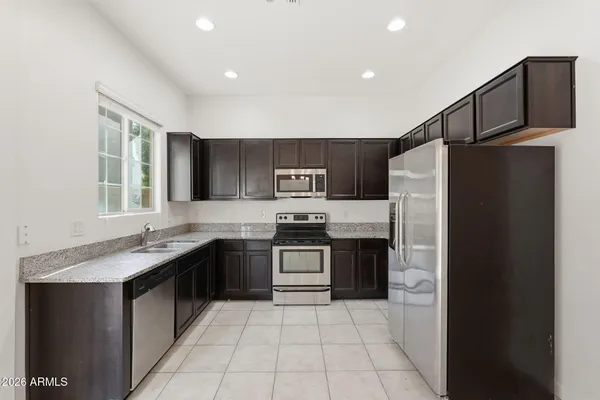 a kitchen with stainless steel appliances granite countertop a refrigerator and a sink