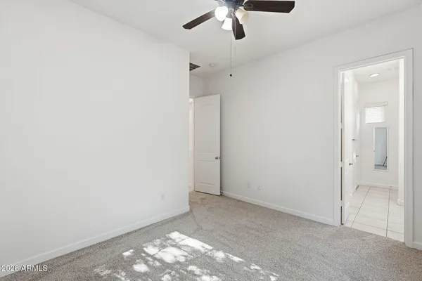 an empty room with a ceiling fan and bathroom