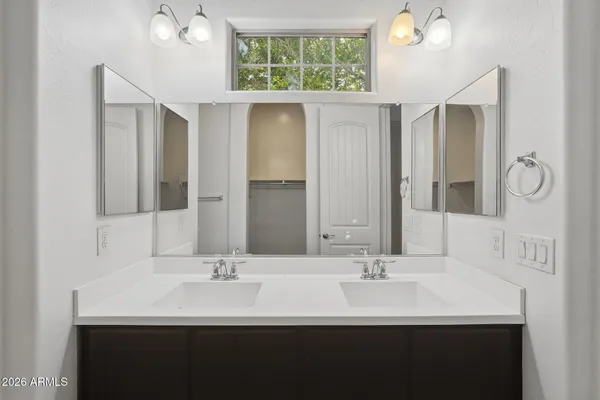 a bathroom with double sink and a mirror