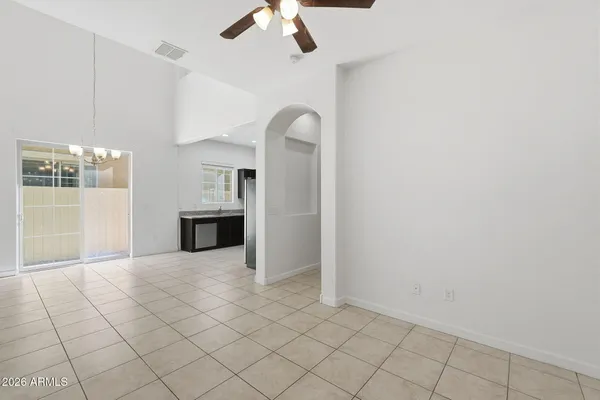 an empty room with windows and ceiling fan