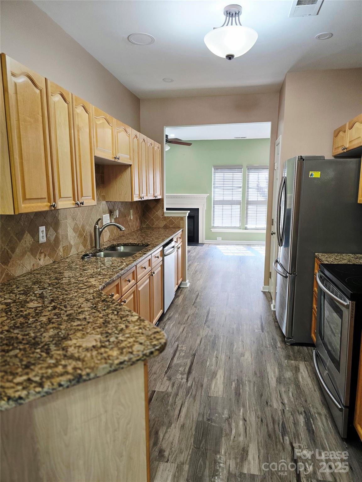 19025 Coachmans Trace Cornelius, NC 28031 - Photo 12 of 34 a kitchen with granite countertop a stove a sink and a microwave
