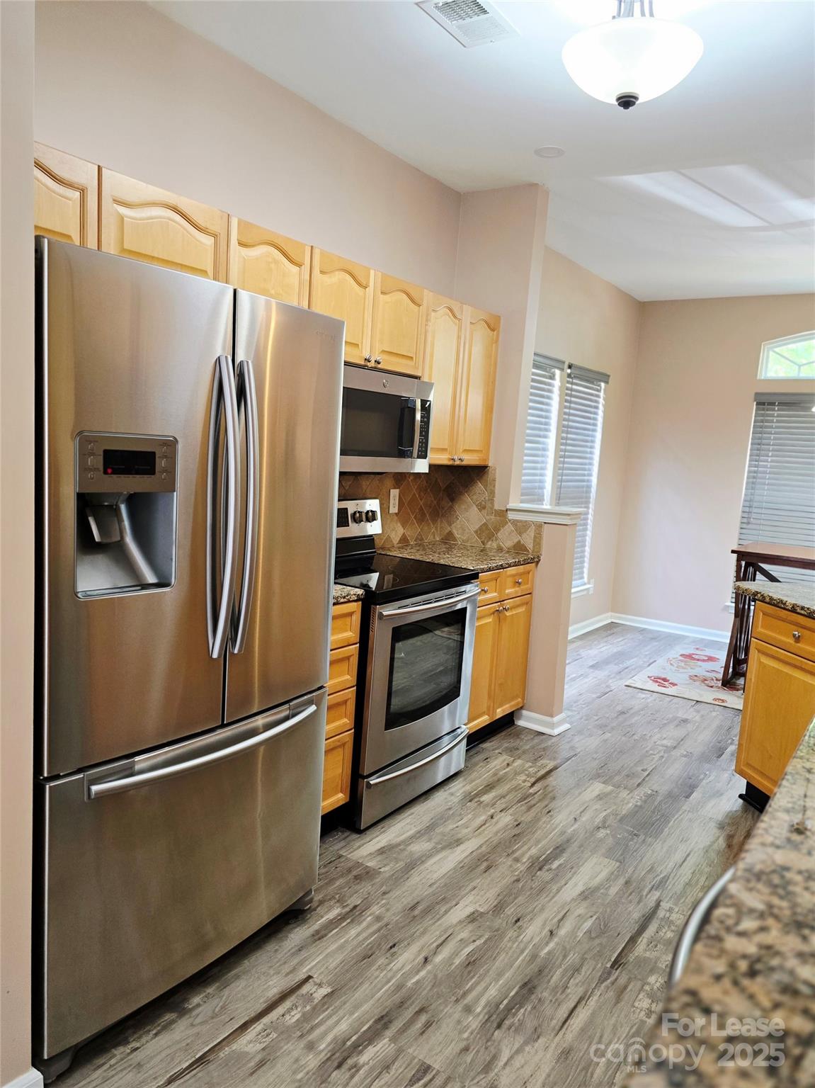 19025 Coachmans Trace Cornelius, NC 28031 - Photo 13 of 34 a kitchen with stainless steel appliances granite countertop a refrigerator microwave and sink