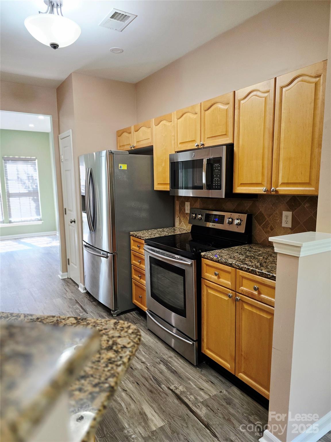 19025 Coachmans Trace Cornelius, NC 28031 - Photo 10 of 34 a kitchen with stainless steel appliances granite countertop a refrigerator stove and microwave