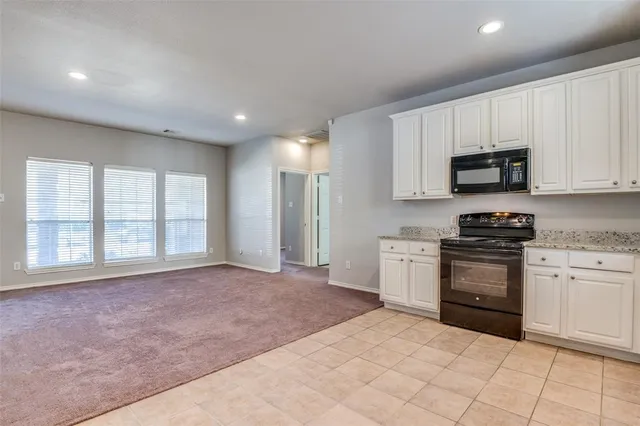 a view of kitchen with granite countertop cabinets and stainless steel appliances