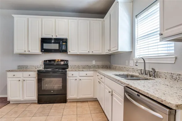 a bathroom with granite countertop a sink a toilet and a window