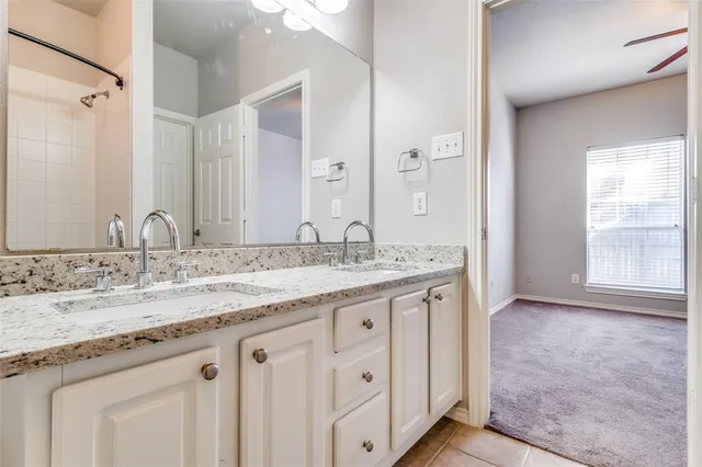 an empty room with chandelier fan and windows